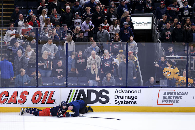 Columbus Blue Jackets' Andrew Peeke is tended to by a trainer during a stop in play against the Boston Bruins in the first period at Nationwide Arena.