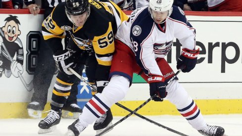 Oliver Bjorkstrand and Jake Guentzel fight for the puck