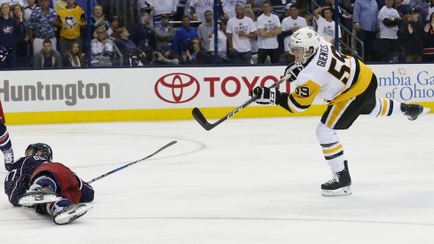 Jake Guentzel shoots the puck over Brandon Dubinsky in overtime