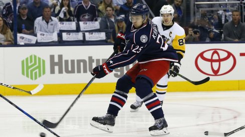 William Karlsson shoots the puck during Game 4 with Sidney Crosby and Urban Meyer looking on.