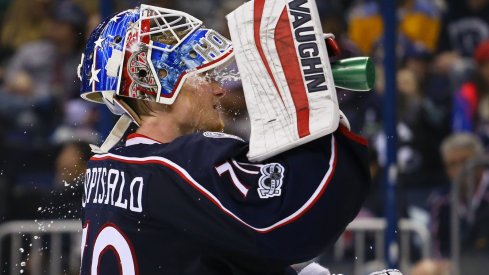 Joonas Korpisalo splashes water on his face before play resumes.