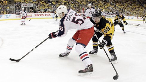 Gabriel Carlsson skates away from Penguins' forwards.