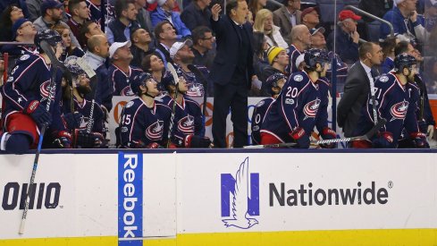 John Tortorella tries to get the referee's attention on the bench