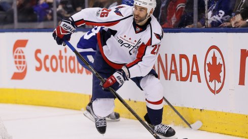 Daniel Winnik attempts to carry the puck out of the zone against the Toronto Maple Leafs