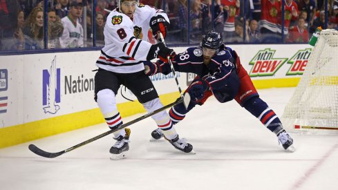 David Savard of the Blue Jackets defends against Nick Schmaltz of the Blackhawks