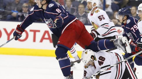 Zach Werenski tries to avoid Blackhawk players during a preseason game