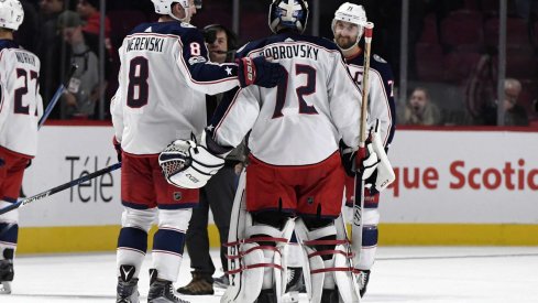 Sergei Bobrovsky meets with Zach Werenski and Nick Foligno at center ice after a victory