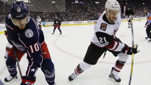 Alexander Wennberg fights for the puck along the wall against Derek Stepan