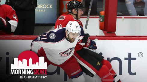 Nick Foligno fights for the puck on the boards against Alexandre Burrows 