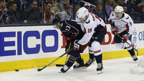 Cam Atkinson and Nicklas Backstrom battle on the boards.