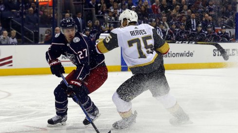 Ryan Murray tries to avoid a hit from forward Ryan Reaves.