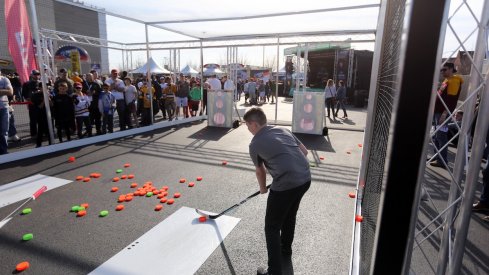 A kid outside the Frozen Four tries his hand at shooting a plastic puck