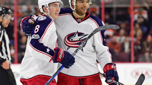 Zach Werenski and Seth Jones celebrate after scoring a goal against the Philadelphia Flyers.