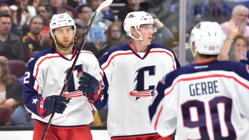 Kevin Stenlund, Nathan Gerbe and Ryan Collins celebrate a goal