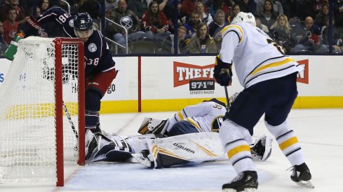 Forward Boone Jenner tries to sneak the puck past goaltender Linus Ullmark