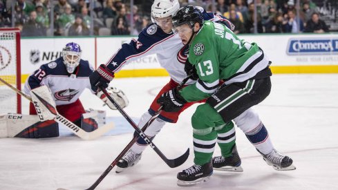 Columbus Blue Jackets defenseman Scott Harrington defends against Mattias Janmark of the Dallas Stars.