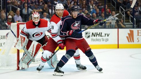 Pierre-Luc Dubois battles with Dougie Hamilton in front of Curtis McElhinney 