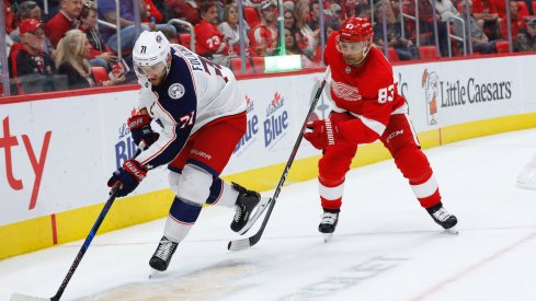 Columbus Blue Jackets captain Nick Foligno protects the puck away from Detroit Red Wings defenseman Trevor Daley during a game at Little Caesars Arena.
