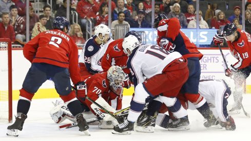 Pierre-Luc Dubois and Oliver Bjorkstrand search for the puck in a scramble in front of the net