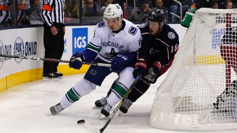 Jake Virtanen carries the puck against Pierre-Luc Dubois in the Vancouver Canucks beat the Columbus Blue Jackets 3-2