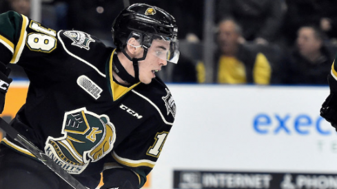 Liam Foudy reaches for the puck and tries to skate up ice