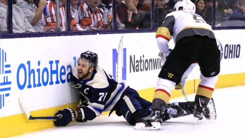 Nick Foligno goes head first into the boards after being checked by the Vegas Golden Knights' Derek Engelland.