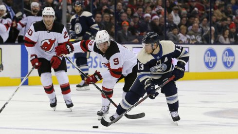 Cam Atkinson skates against Taylor Hall as the Columbus Blue Jackets take on the New Jersey Devils