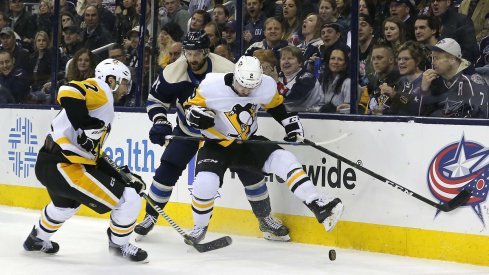 Chad Ruhwedel kicks the loose puck away from Nick Foligno at Nationwide Arena