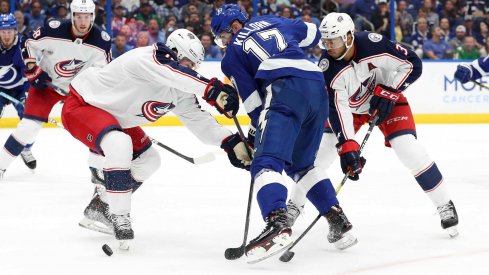 Zach Werenski and Seth Jones tie up Alex Killorn in Game 1 against the Tampa Bay Lightning