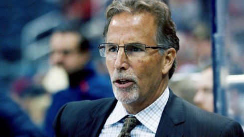 Head coach John Tortorella stands on the bench during a game