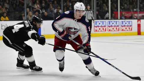 Columbus Blue Jackets defenseman Zach Werenski protects the puck against Nate Thompson of the Los Angeles Kings during a game at STAPLES Center.