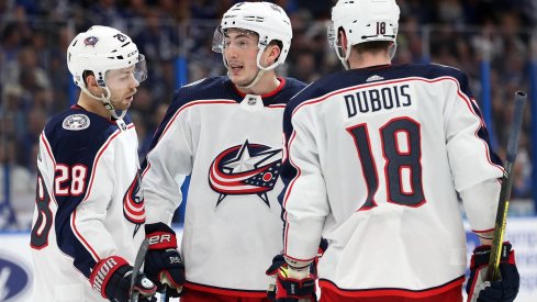 Zach Werenski, Oliver Bjorkstrand, and Pierre-Luc Dubois chat during the second period of game one of the first round of the 2019 Stanley Cup Playoffs against the Tampa Bay Lightning 