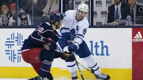 Columbus Blue Jackets center Alexander Wennberg defends against Toronto Maple Leafs center John Tavares during a game at Nationwide Arena.