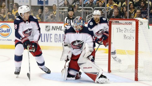 Oct 5, 2019; Pittsburgh, PA, USA; Columbus Blue Jackets goaltender Elvis Merzlikins (90) makes a save as defenseman Zach Werenski (8) defends against the Pittsburgh Penguins during the second period at PPG PAINTS Arena. The Penguins won 7-2.