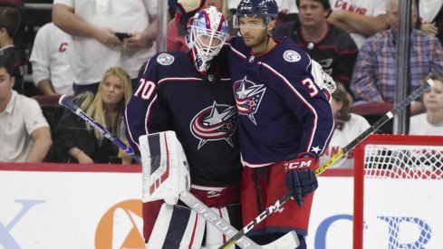 Joonas Korpisalo and Seth Jones celebrate after a 3-2 win over the Carolina Hurricanes on Saturday night.