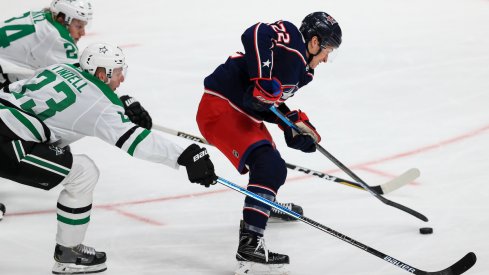 Columbus Blue Jackets left wing Sonny Milano (22) controls the puck Dallas Stars defenseman Esa Lindell (23) and left wing Roope Hintz (24) in the third period at Nationwide Arena.