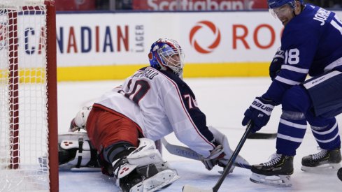 Columbus Blue Jackets goaltender Joonas Korpisalo spreads out to make a save against Andreas Johnsson of the Toronto Maple Leafs during a regular-season matchup during October of 2019.