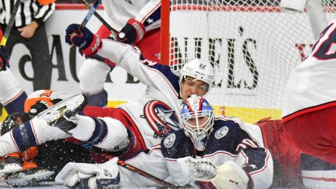 Oct 26, 2019; Philadelphia, PA, USA; Columbus Blue Jackets goaltender Joonas Korpisalo (70) and left wing Sonny Milano (22) keep the puck out of the net against the Philadelphia Flyers during the second period at Wells Fargo Center.