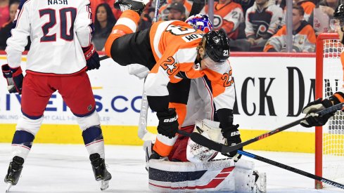 Oct 26, 2019; Philadelphia, PA, USA; Philadelphia Flyers left wing Oskar Lindblom (23) trips over Columbus Blue Jackets goaltender Joonas Korpisalo (70) during the second period at Wells Fargo Center.