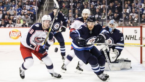 Jan 31, 2019; Winnipeg, Manitoba, CAN; Winnipeg Jets defenseman Ben Chiarot (7) and Columbus Blue Jackets forward Pierre Luc Dubois (18) eye the puck during the second period at Bell MTS Place.