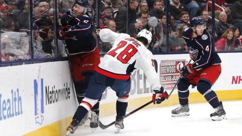  Washington Capitals left wing Brendan Leipsic (28) checks Columbus Blue Jackets defenseman Andrew Peeke (2) during the third period at Nationwide Arena.