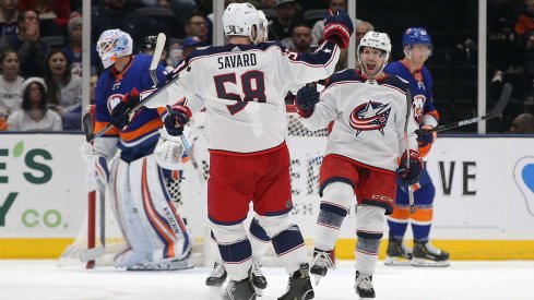 Dec 23, 2019; Uniondale, New York, USA; Columbus Blue Jackets left wing Nathan Gerbe (24) celebrates his goal against New York Islanders goalie Thomas Greiss (1) with Blue Jackets defenseman David Savard (58) during the second period at Nassau Veterans Memorial Coliseum.