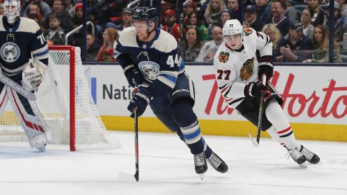 Columbus Blue Jackets defenseman Vladislav Gavrikov (44) carries the puck away from Chicago Blackhawks center Kirby Dach (77) during the second period at Nationwide Arena.