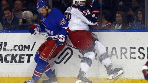 New York Rangers defenseman Brendan Smith (42) and Columbus Blue Jackets defenseman David Savard (58) battle for the puck during the second period at Madison Square Garden.