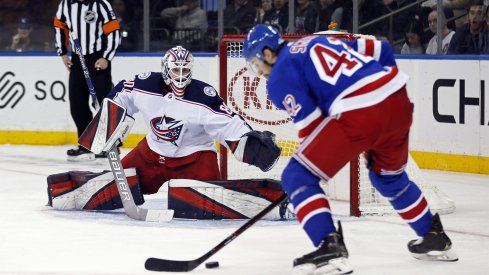 Jan 19, 2020; New York, New York, USA; Columbus Blue Jackets goaltender Matiss Kivlenieks (80) defends against New York Rangers defenseman Brendan Smith (42) during the second period at Madison Square Garden.