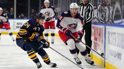 Mar 31, 2019; Buffalo, NY, USA; Buffalo Sabres defenseman Lawrence Pilut (24) and Columbus Blue Jackets center Pierre-Luc Dubois (18) go after a loose puck during the first period at KeyBank Center.