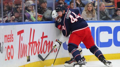 Feb 13, 2020; Buffalo, New York, USA; Columbus Blue Jackets defenseman Vladislav Gavrikov (44) pins Buffalo Sabres left wing Victor Olofsson (68) on the boards as he goes for the puck during the second period at KeyBank Center.