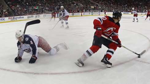 New Jersey Devils center Blake Coleman (20) plays the puck against Columbus Blue Jackets defenseman Scott Harrington (4) during the second period at Prudential Center. 