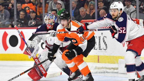 Feb 18, 2020; Philadelphia, Pennsylvania, USA; Philadelphia Flyers left wing Joel Farabee (49) fights for position with Columbus Blue Jackets center Emil Bemstrom (52) in front of goaltender Elvis Merzlikins (90) during the second period during the first period at Wells Fargo Center.