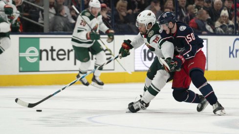 Feb 28, 2020; Columbus, Ohio, USA; Minnesota Wild left wing Jordan Greenway (18) and Columbus Blue Jackets left wing Eric Robinson (50) battle for the puck during the game at Nationwide Arena.